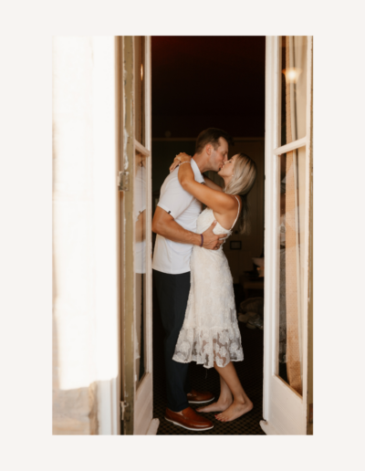 Bride and groom kissing between two paneled doors